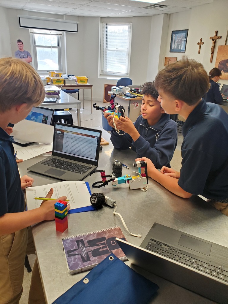 Two students work together to fix their robot.