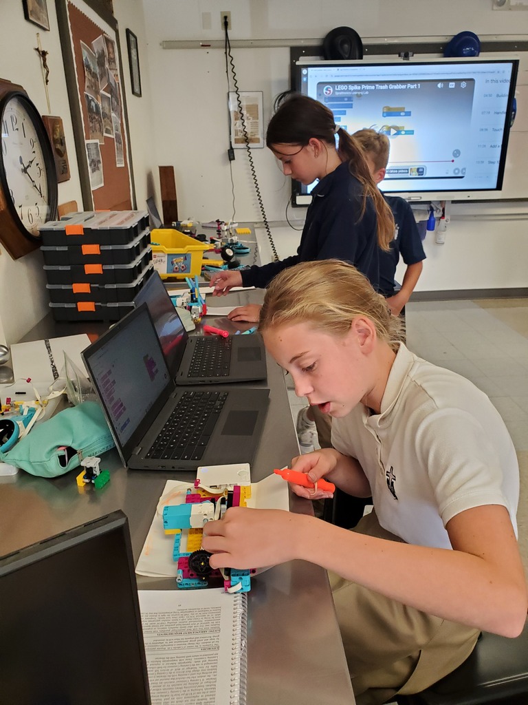 Two female students test their robots' functionality.