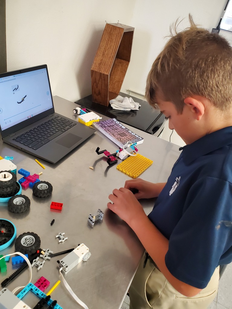 A student places the next piece in building his robot.