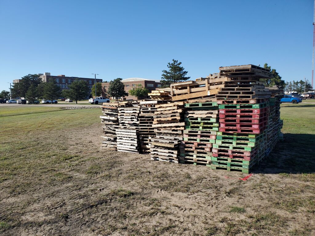 Wooden pallets are stacked in front of TMP-Marian for a bonfire