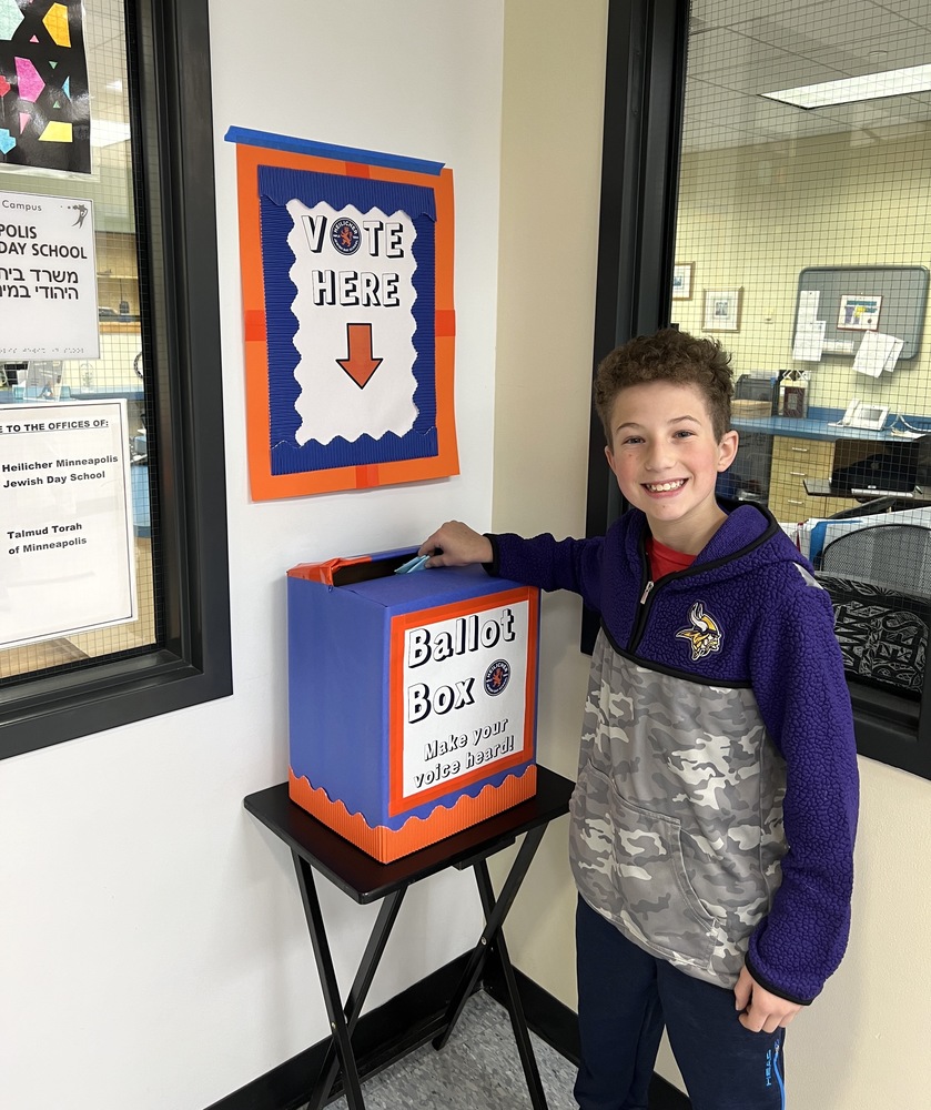student drops ballot into ballot box