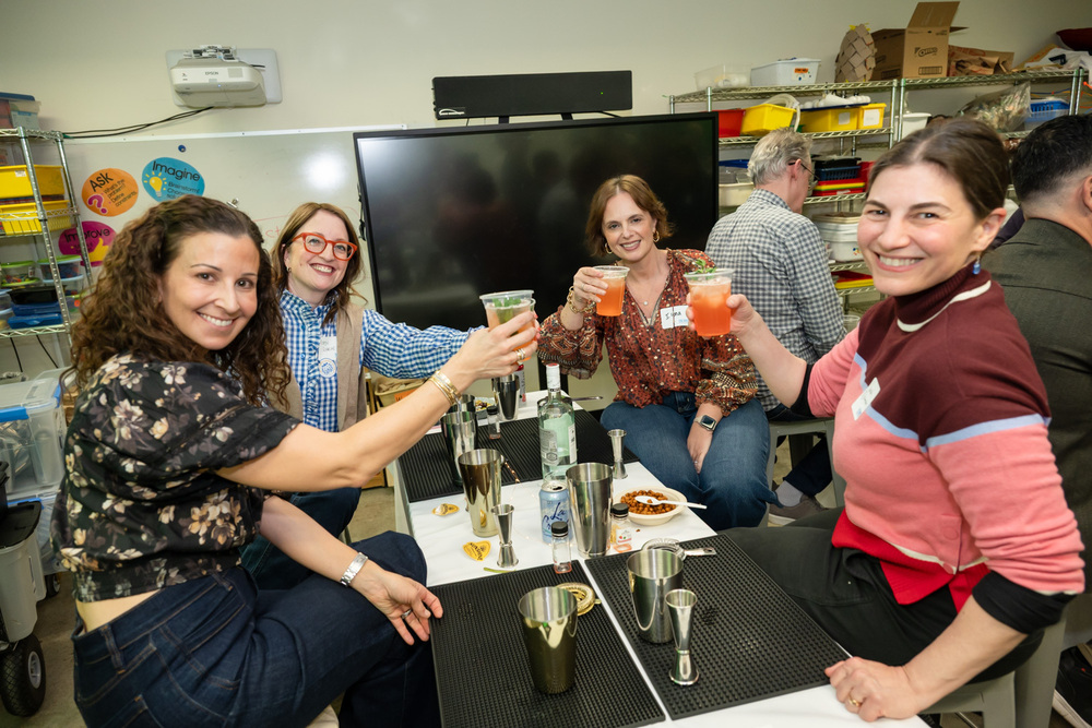 women lift drinks in toast at annual benefit