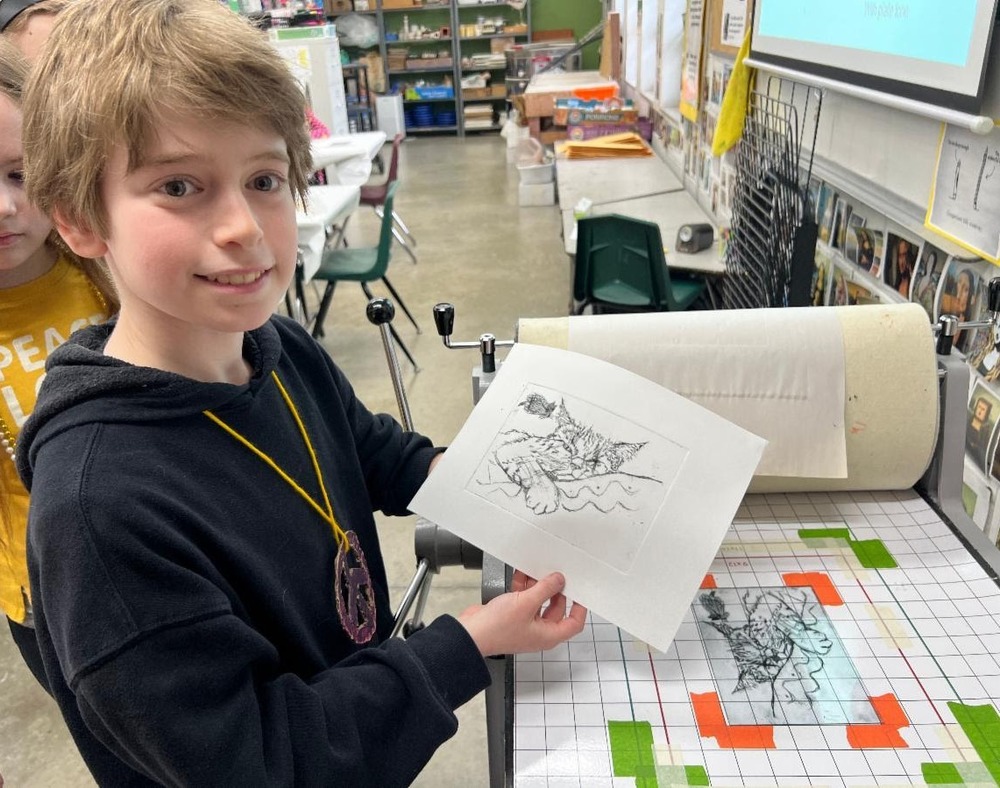 student shows cat print he made using SJA's printmaking press