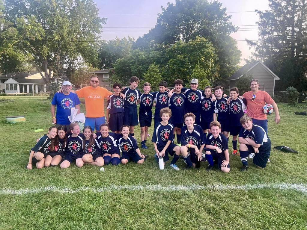 Soccer team posing for a picture after a game
