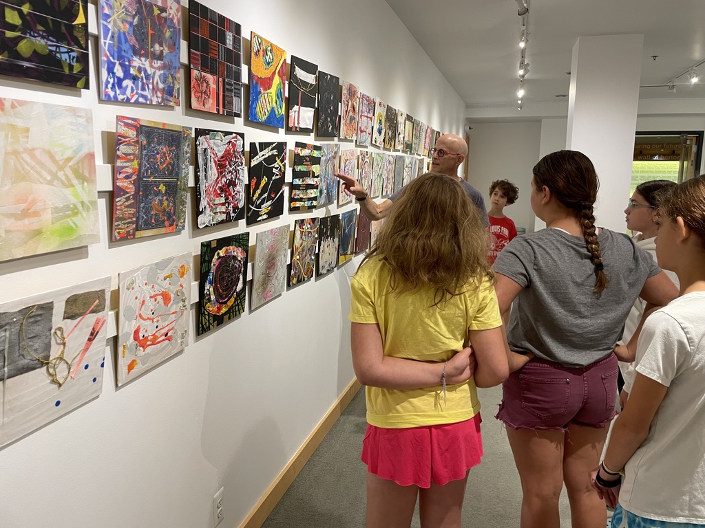 Owen points to wall of art as children watch