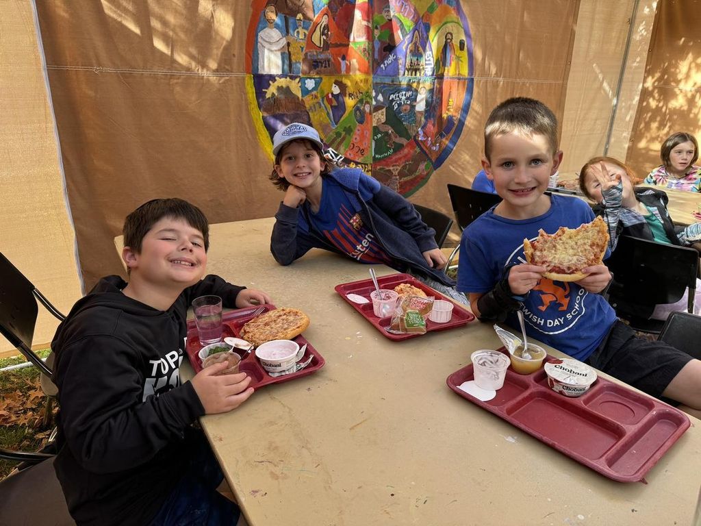 students eat lunch in the sukkah