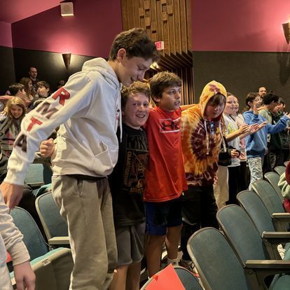 students sway with arms around each other