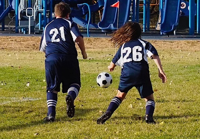 two heilicher players run after soccer ball