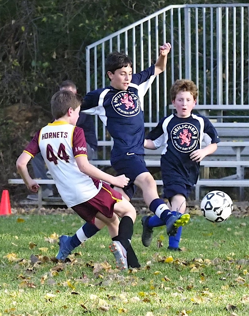 heilicher player kicks soccer ball away from defender