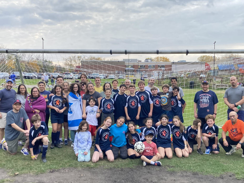 soccer players and parents pose in goal