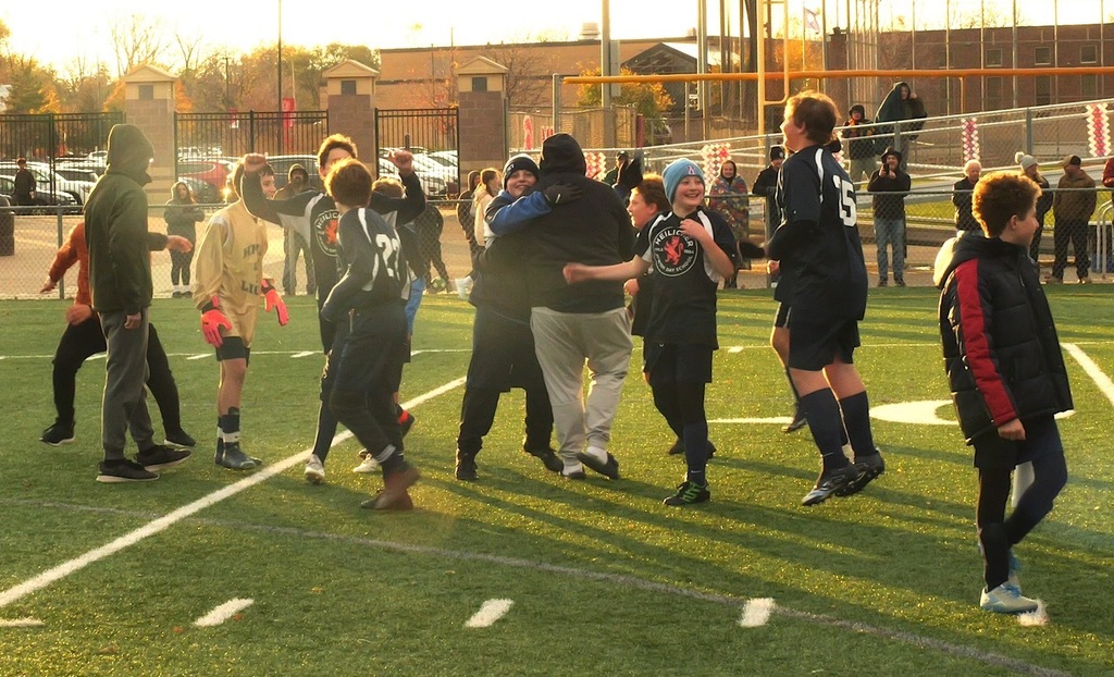 heilicher soccer team jumps and hugs