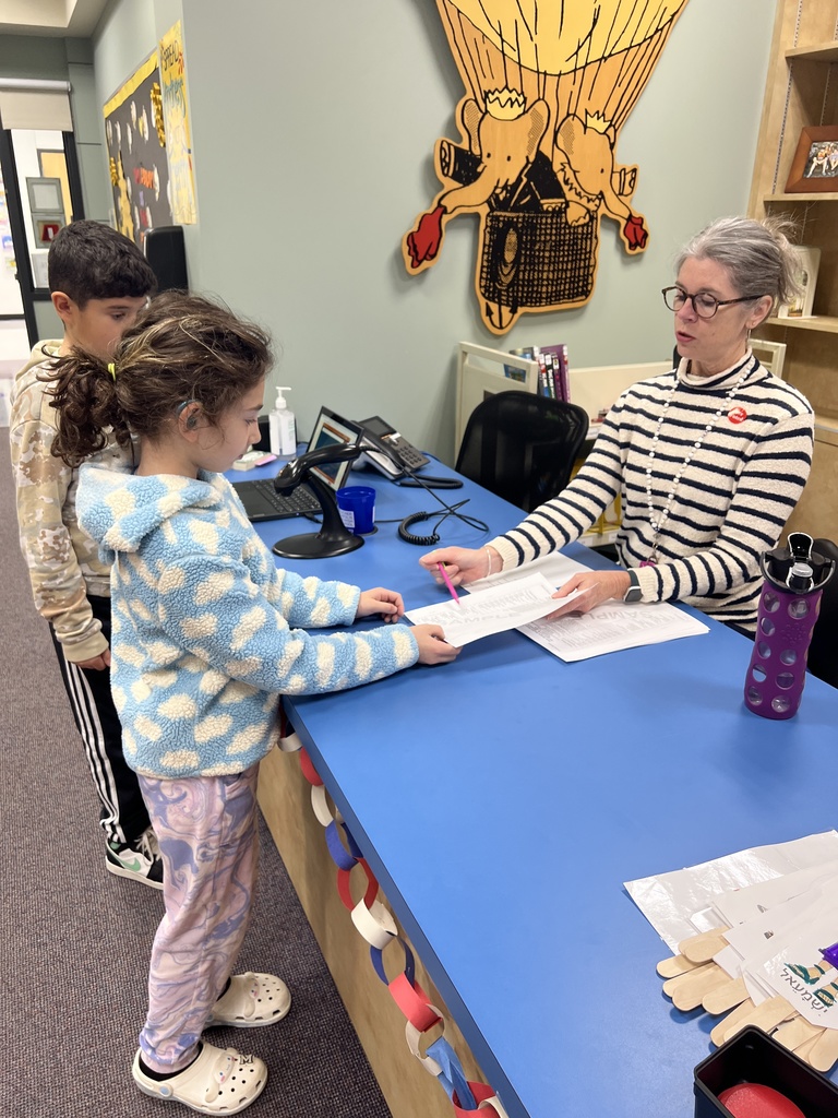 librarian shows two fifth grade students how to fill out their sample ballots