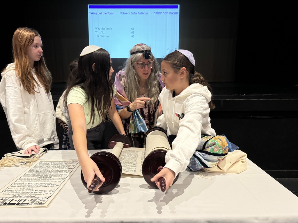 two seventh-grade girls prepare to lift the Torah