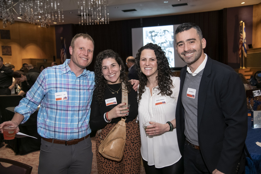 two couples pose in social hall