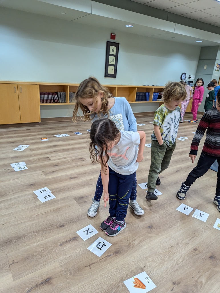 student points to letter as she reads to partner