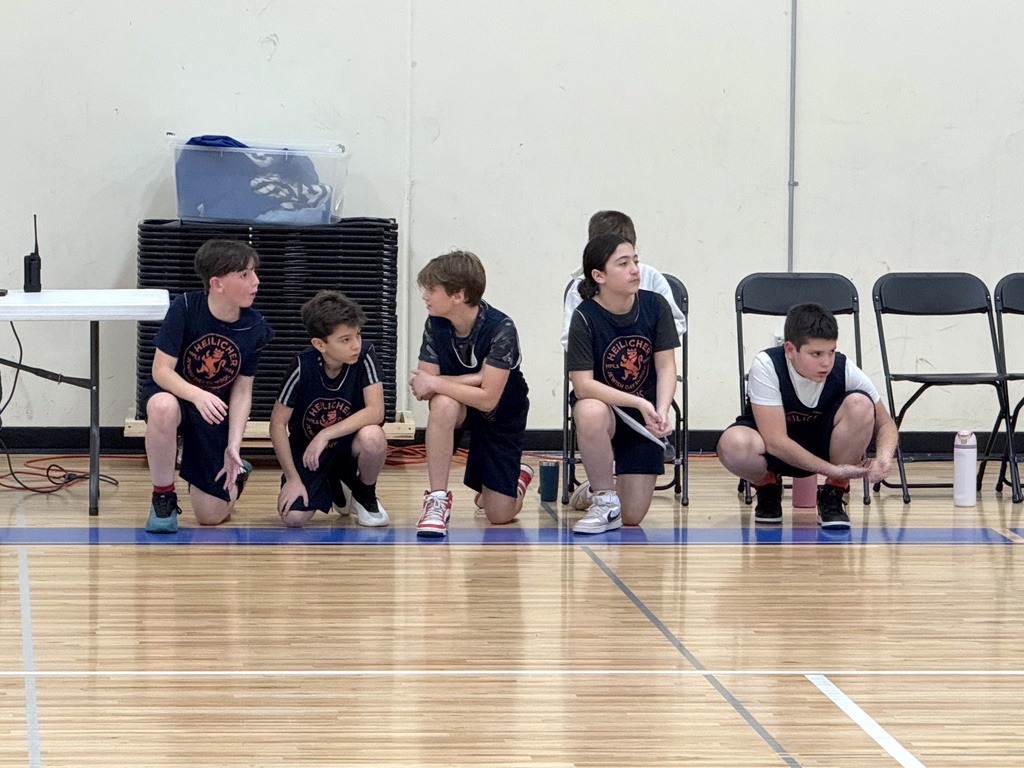 players kneel on sideline ready to play basketball