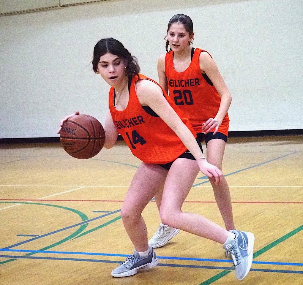 student dribbles basketball