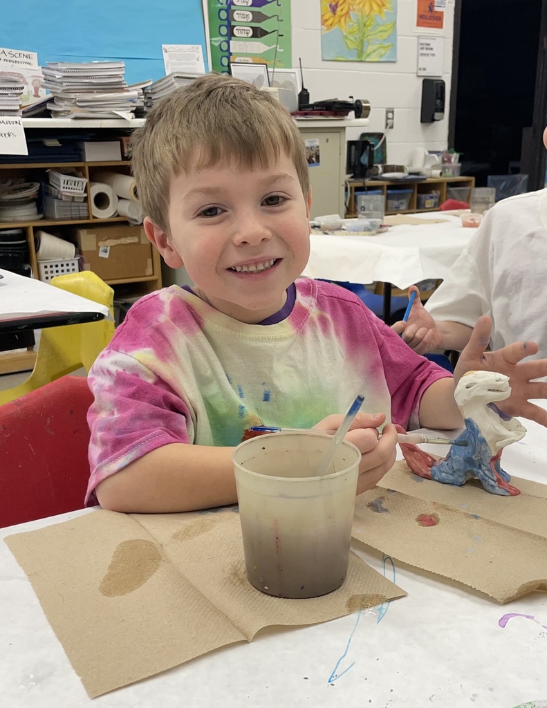 student glazes clay animals