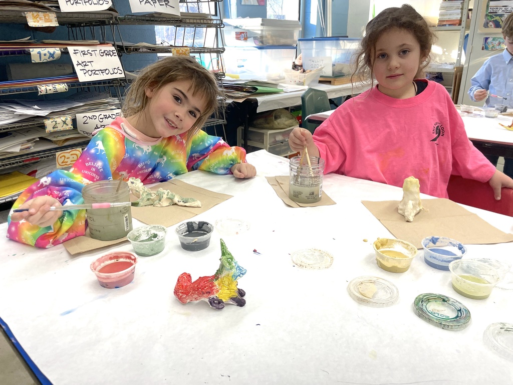 two students glaze clay animals