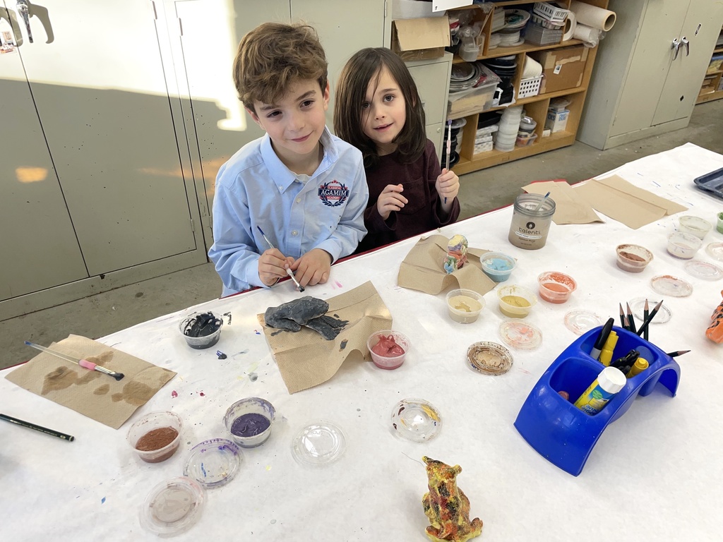 two students glaze clay animals
