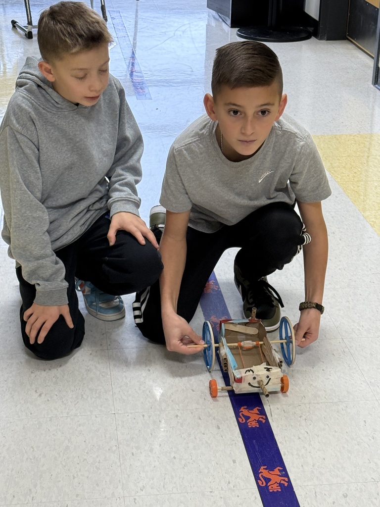 boys set up rover to propel itself down hallway