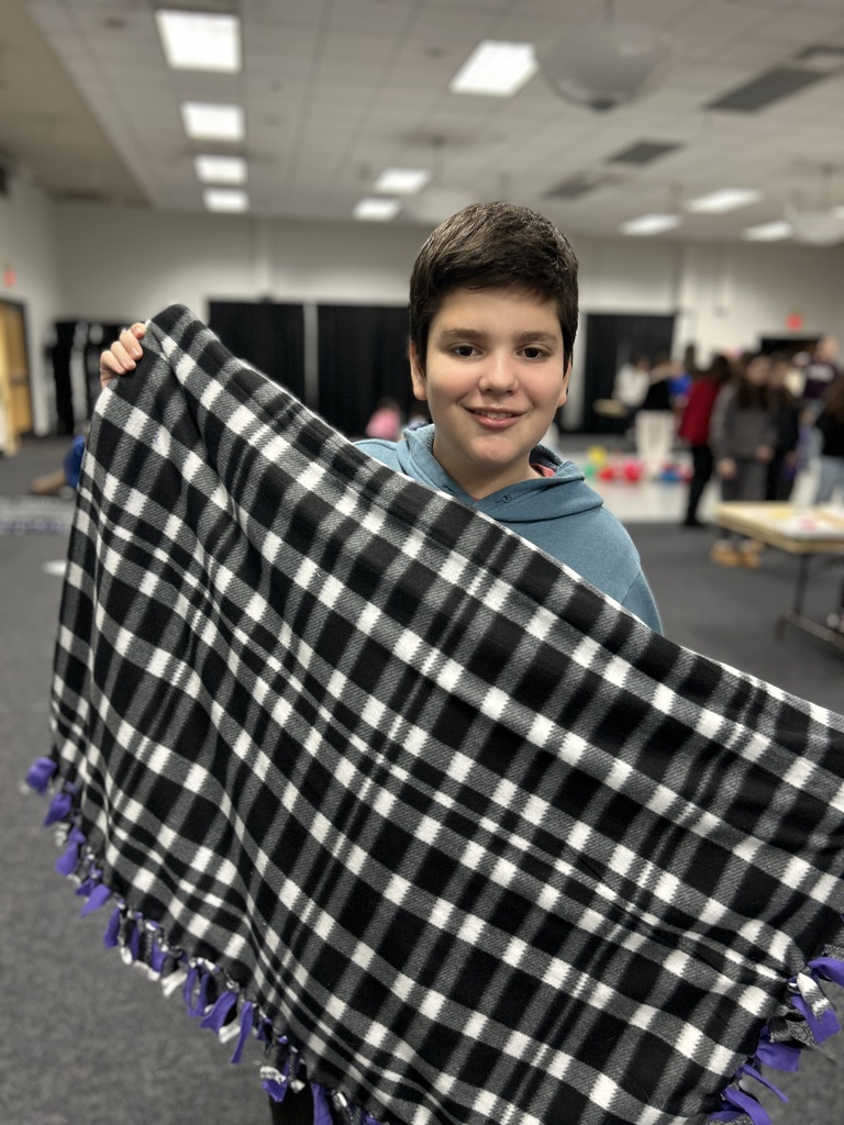 student shows finished tie blanket