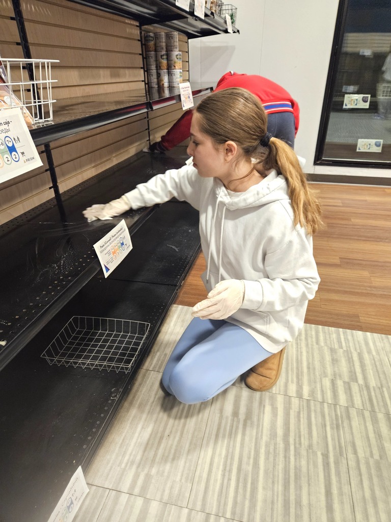 student cleans shelf