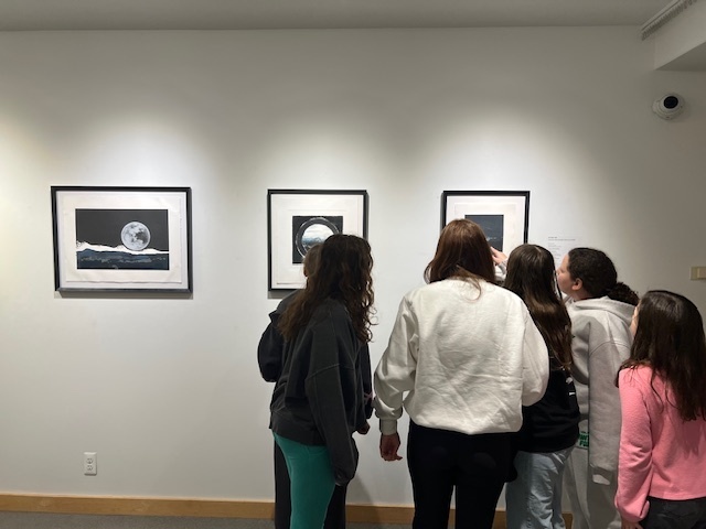 students look at framed art