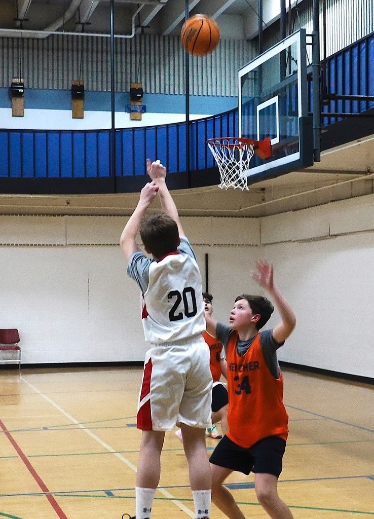 opposing basketball player shoots ball
