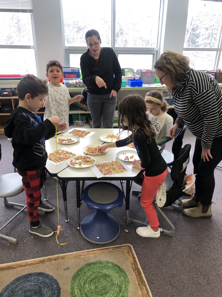 students make cereal necklaces with parent volunteers