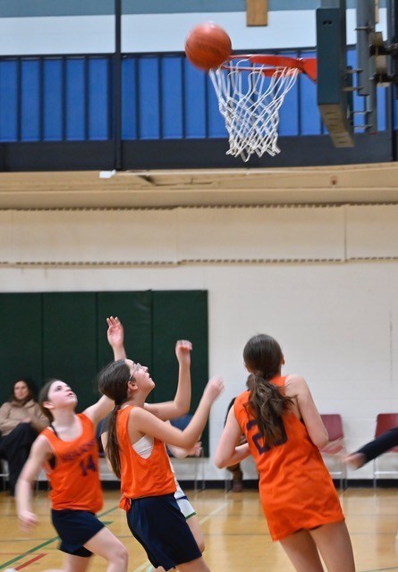 basketball players reach for rebound