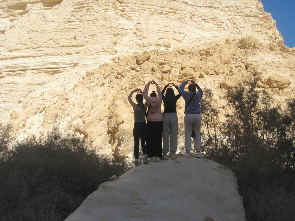 students make heart shapes with hands in the nature