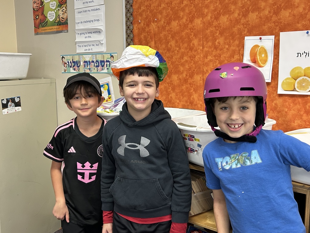 three boys with funny hats: black hat, beach ball as a hat, and purple helmet