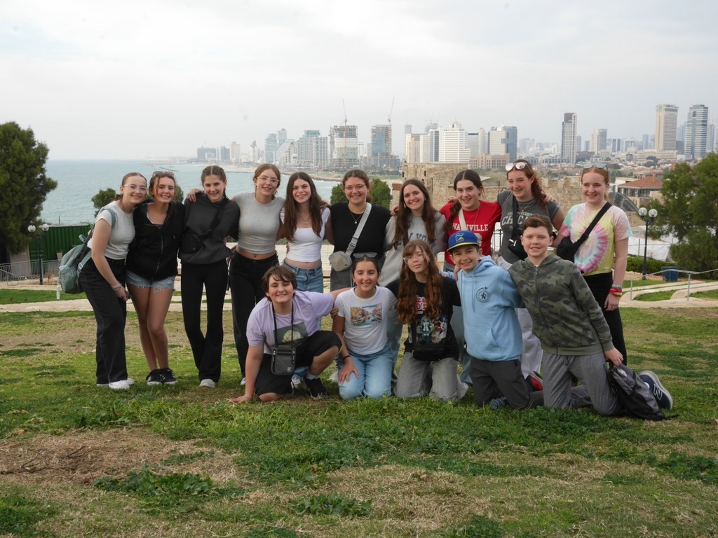 Aliyah Chet poses with city skyline and sea behind them