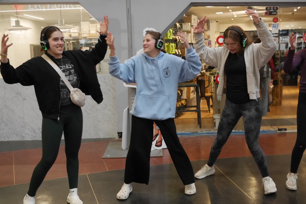Aliyah Chet wearing headphones dances in mall
