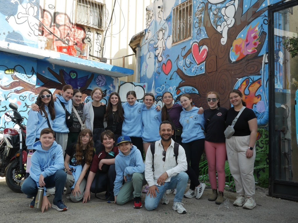 Aliyah Chet in front of graffiti mural