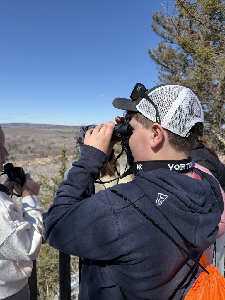 student looks through binoculars