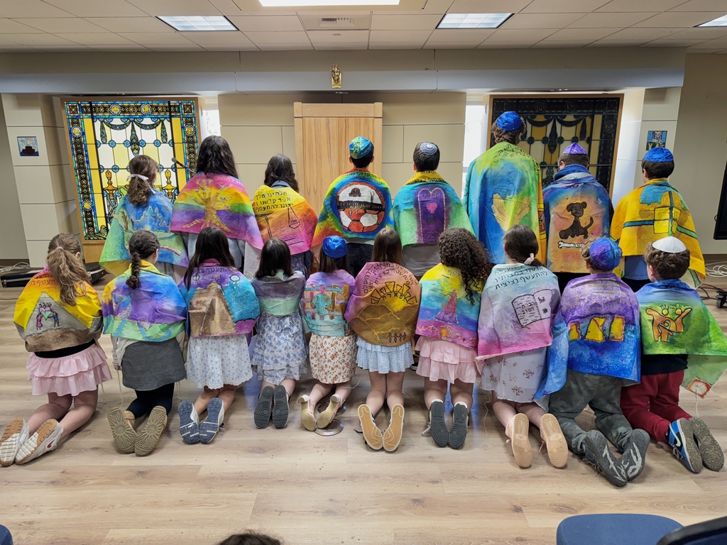 sixth graders in talitot from behind, showing designs