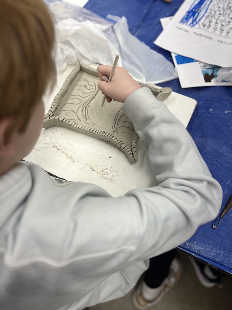 student etches design into clay