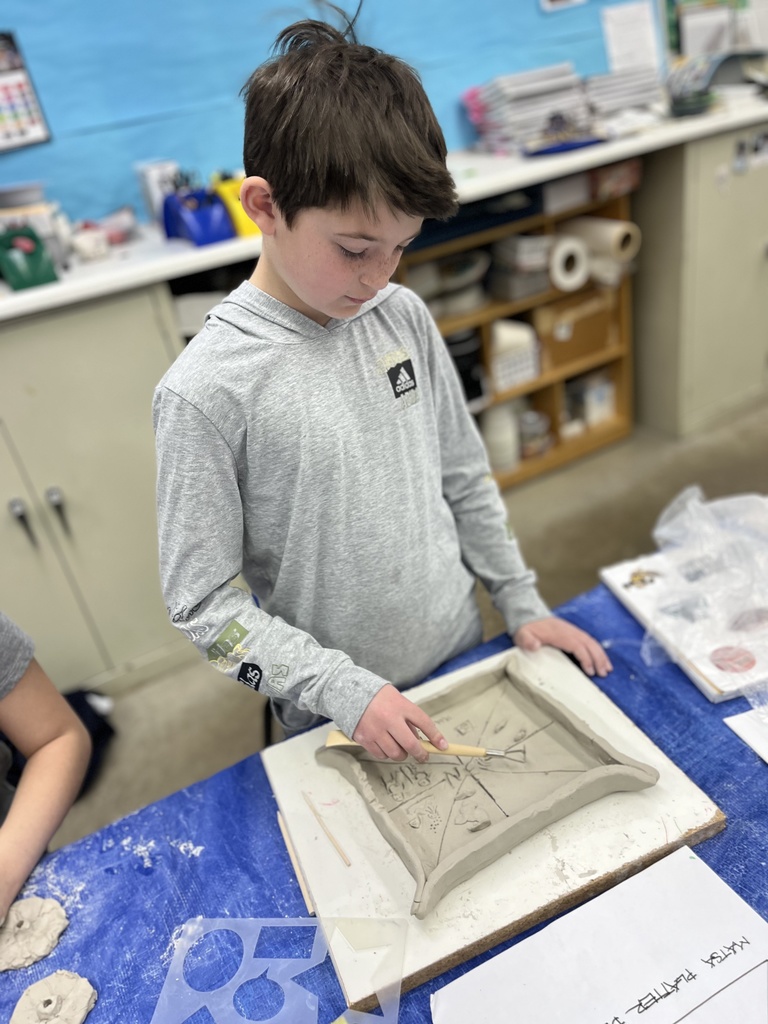 student etches design into clay