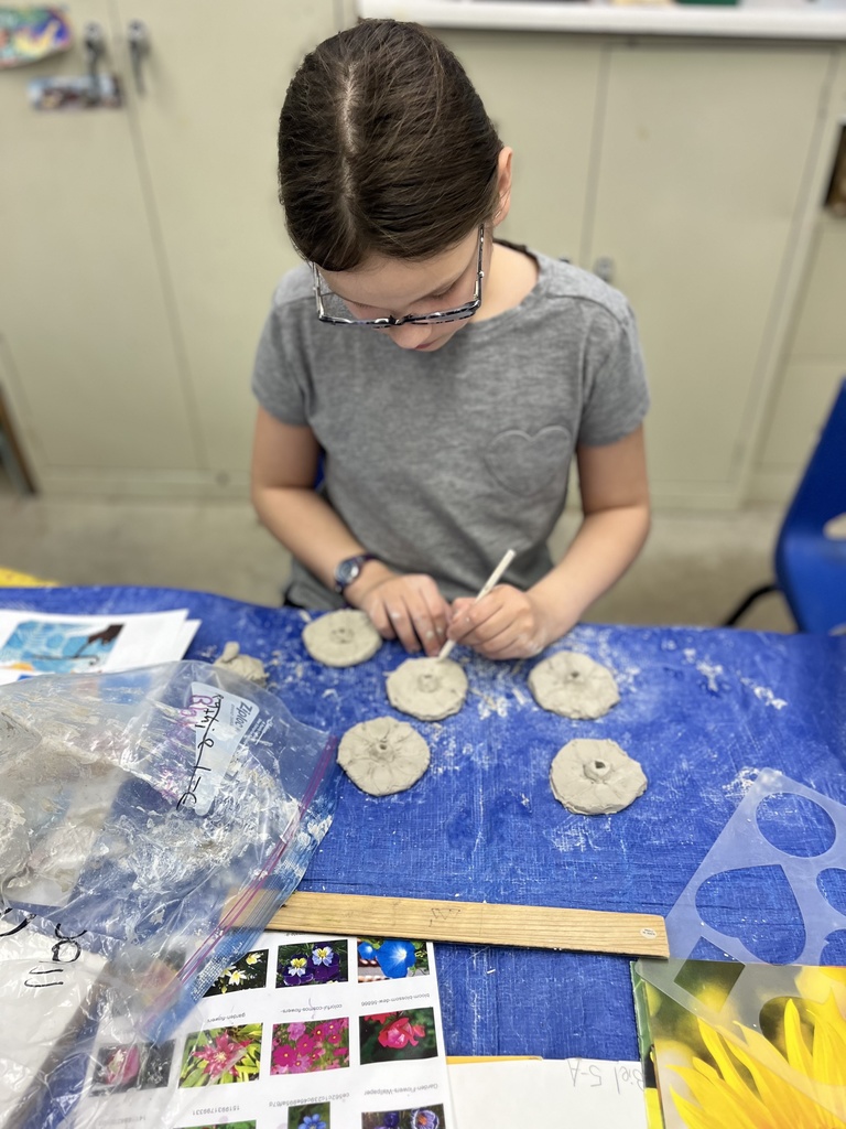 student etches design into clay