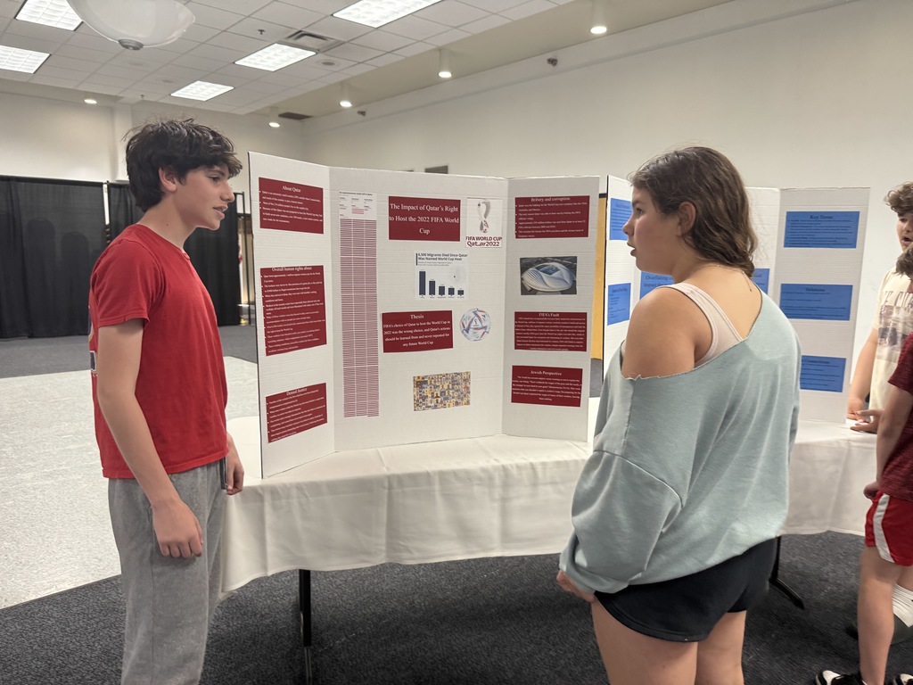 eighth grader presents to younger student