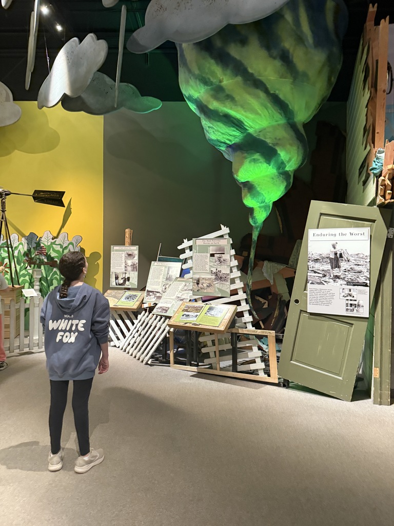 student looks at tornado exhibit