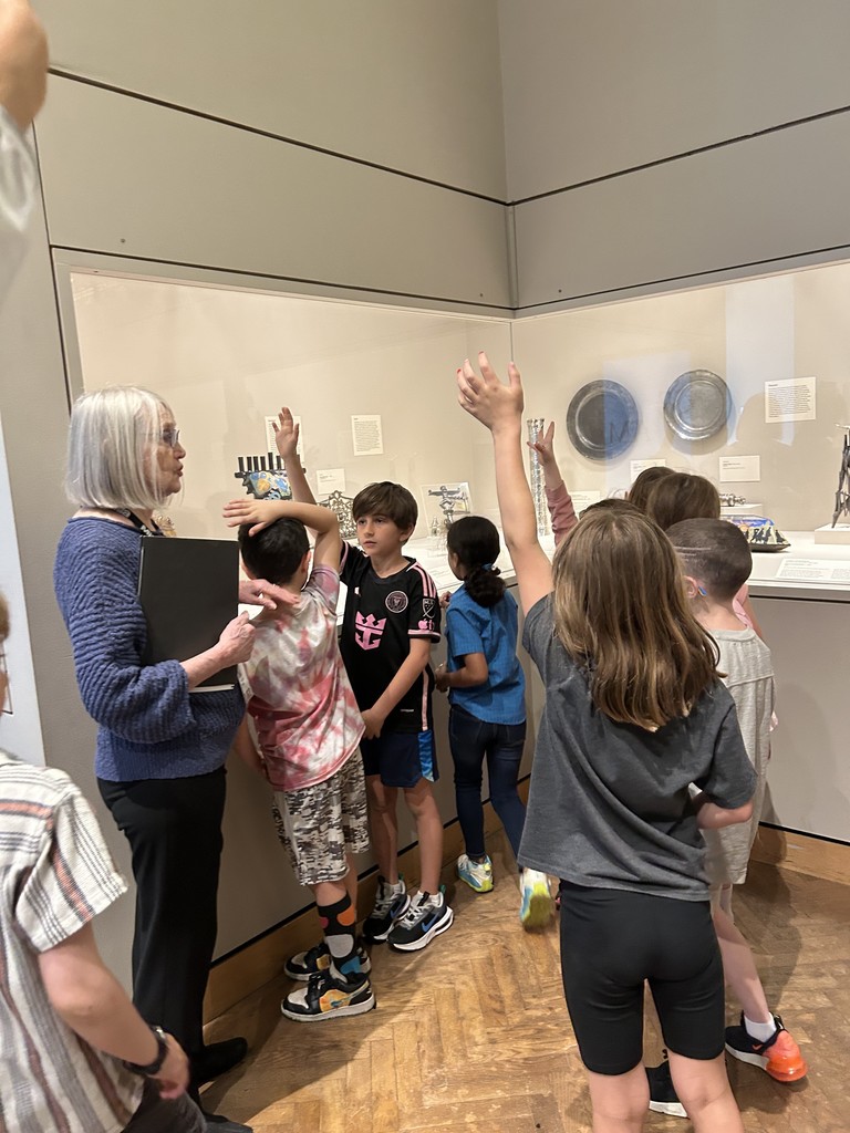 students raise hands in Harold and Mickey Smith Gallery of Jewish Arts and Culture