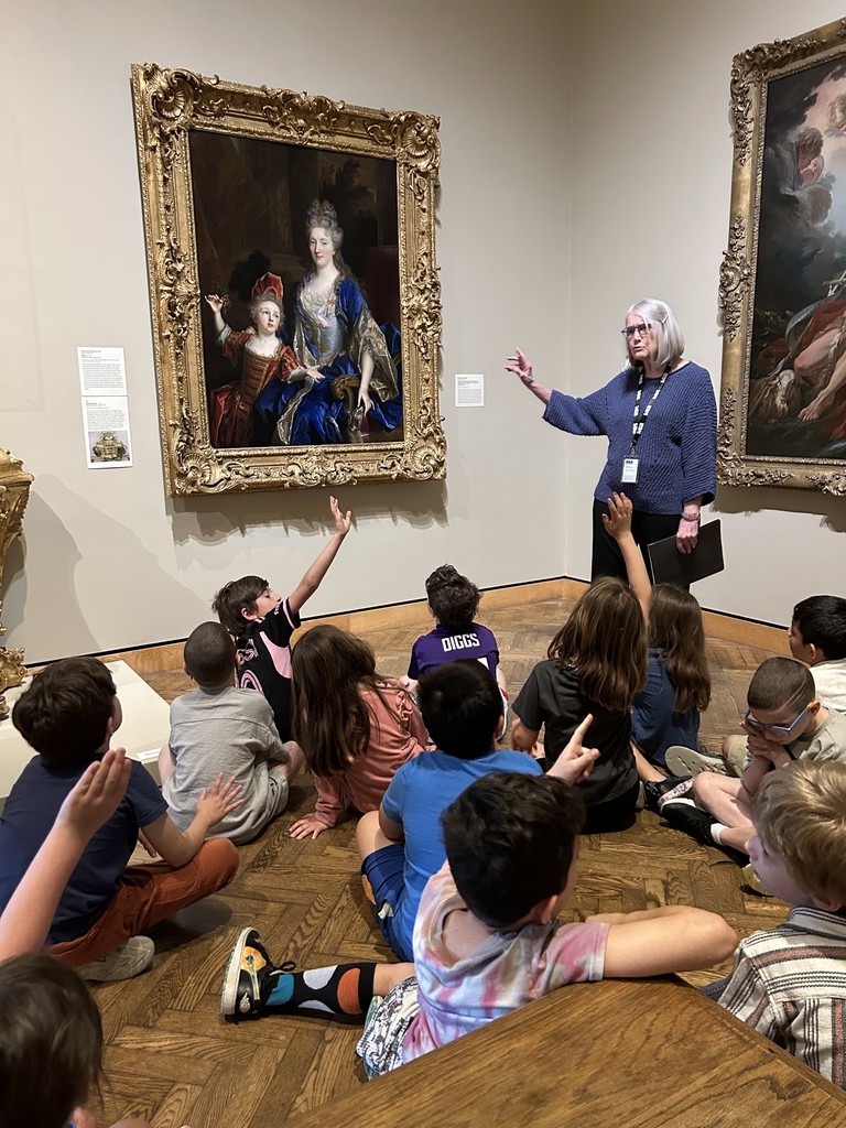 students raise hands as docent tells about painting