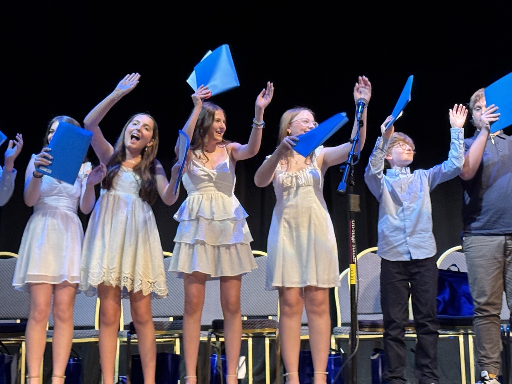 eighth graders sing and wave arms