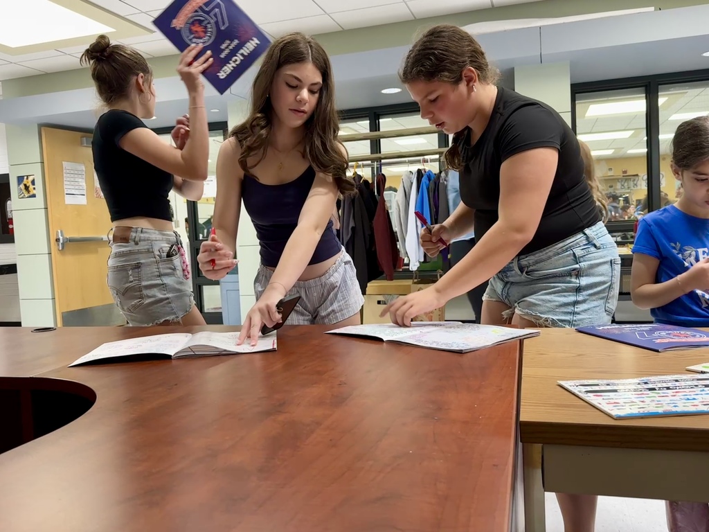 students sign each other's yearbooks