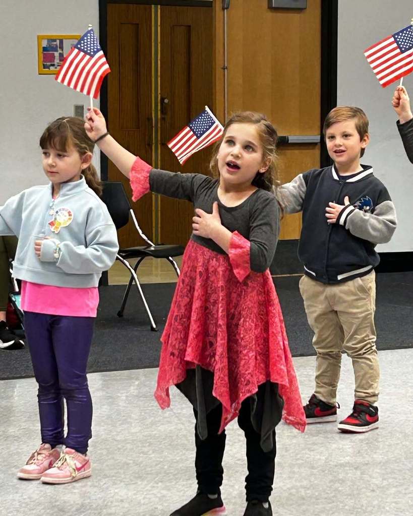 kindergartners wave American flags