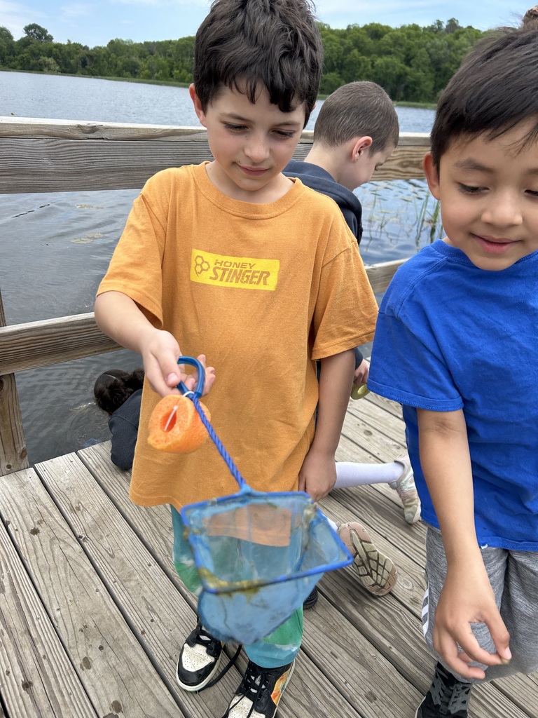 students hold invertebrate in fish net
