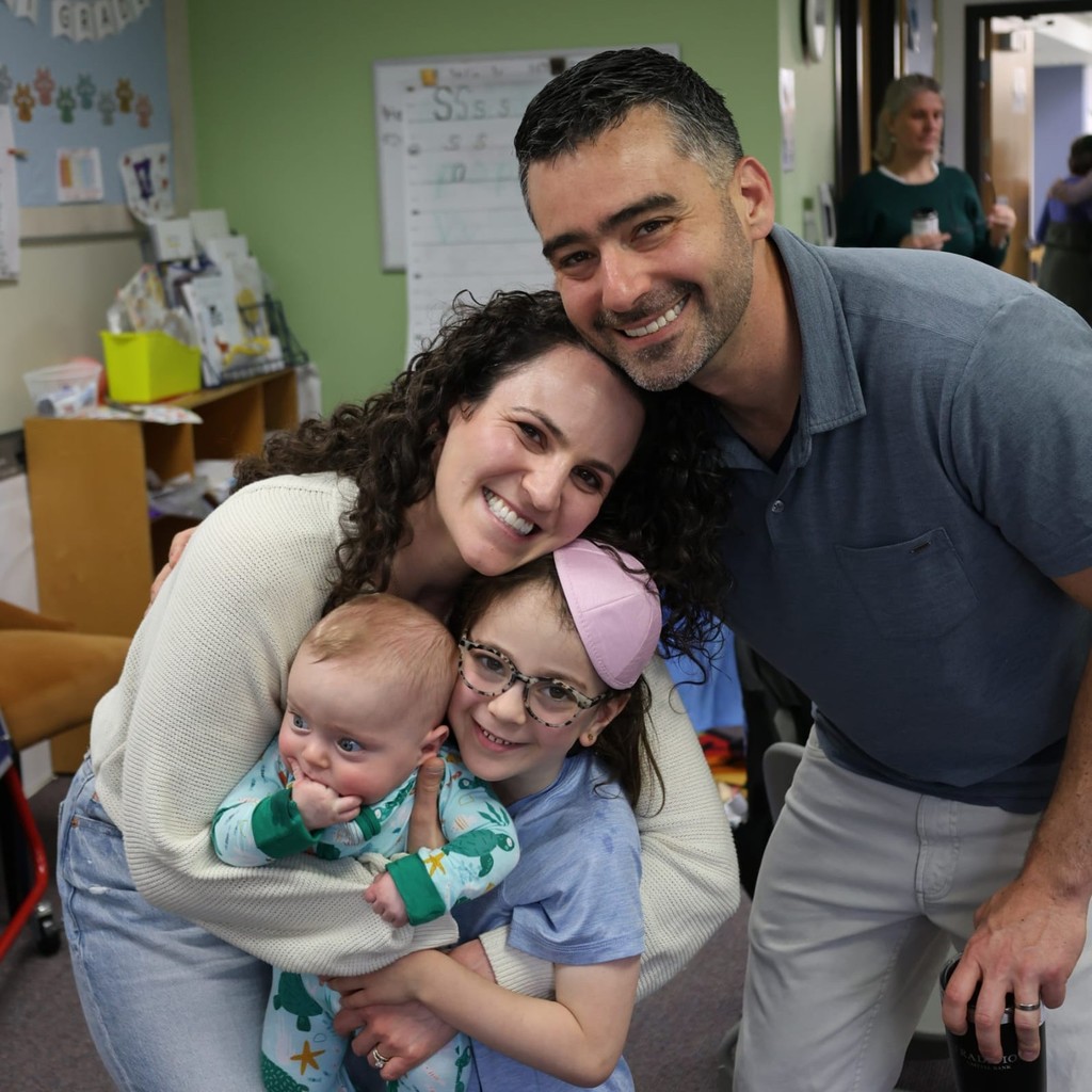 parents hug student and younger sibling